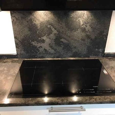 Flächenbündiges Kochfeld eingebaut in einer Küche mit einer Küchenarbeitsplatte aus Mystic Grey satiniert