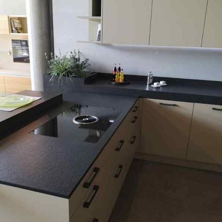 Küchenarbeitsplatte aus Nero Assoluto antik mit einem flächenbündig eingebautem Kochfeld