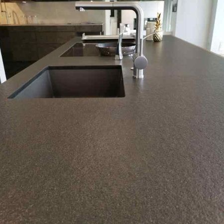 Küchenarbeitsplatte aus Nero Assoluto antik mit einem Spülenausschnitt Unterbau und einem flächenbündigem Kochfeldausschnitt