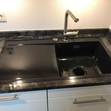 Spüle flächenbündig eingebaut in eine Küchenarbeitsplatte aus Mystic Grey poliert